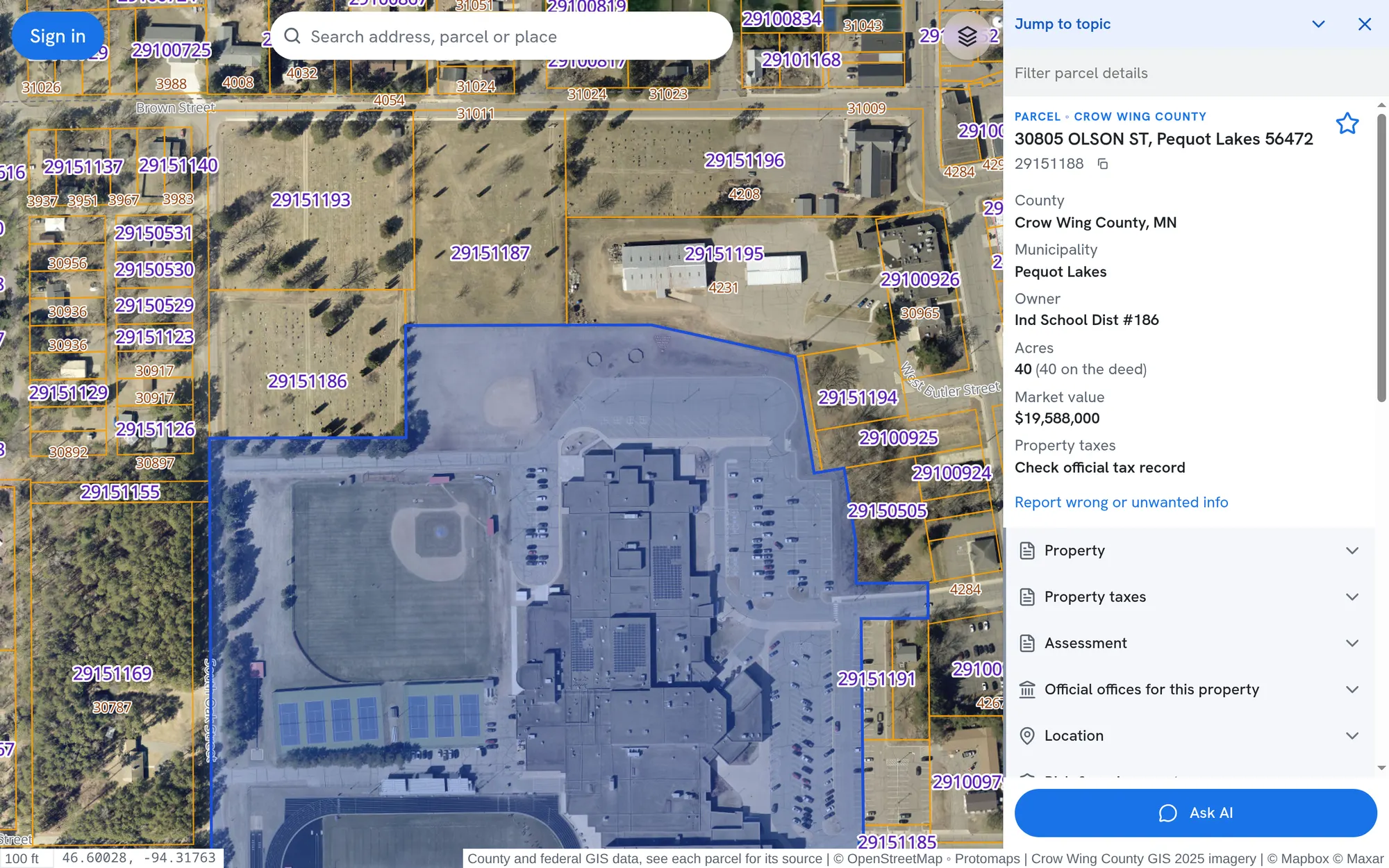 The PublicGIS map over satellite imagery of Pequot Lakes, Minnesota, with parcel lines drawn and the school district's 40 acre parcel open beside the map